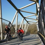 Commuting cyclists on the bridge over Winston Street, an impressive part of the CVG, in Burnaby