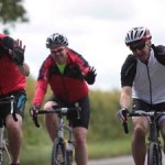 friendly cyclists waving from their bikes